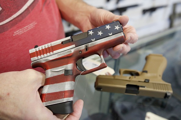 A worker restocks handguns at Davidson Defense in Orem, Utah on March 20, 2020. - Gun stores in the US are reporting a surge in sales of firearms as coronavirus fears trigger personal safety concerns.