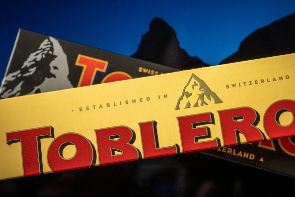A picture taken on March 6, 2023, shows packagings of Toblerone chocolate bars owned by US firm Mondelez with a representation of the Matterhorn mountain (back) and of a generic mountain (front) in Geneva. Toblerone is to remove the Swiss iconic Matterhorn peak from its packaging when some of the chocolate's production is moved from Switzerland to Slovakia and replaced by a more generic mountain under strict 