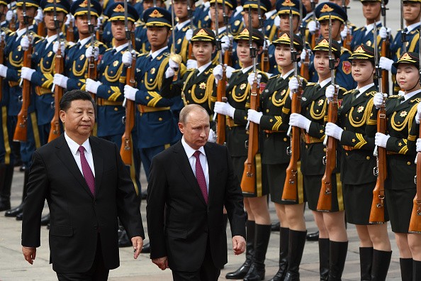 Russia's President Vladimir Putin (C) reviews a military honour guard with Chinese President Xi Jinping (L) during a welcoming ceremony outside the Great Hall of the People in Beijing on June 8, 2018.